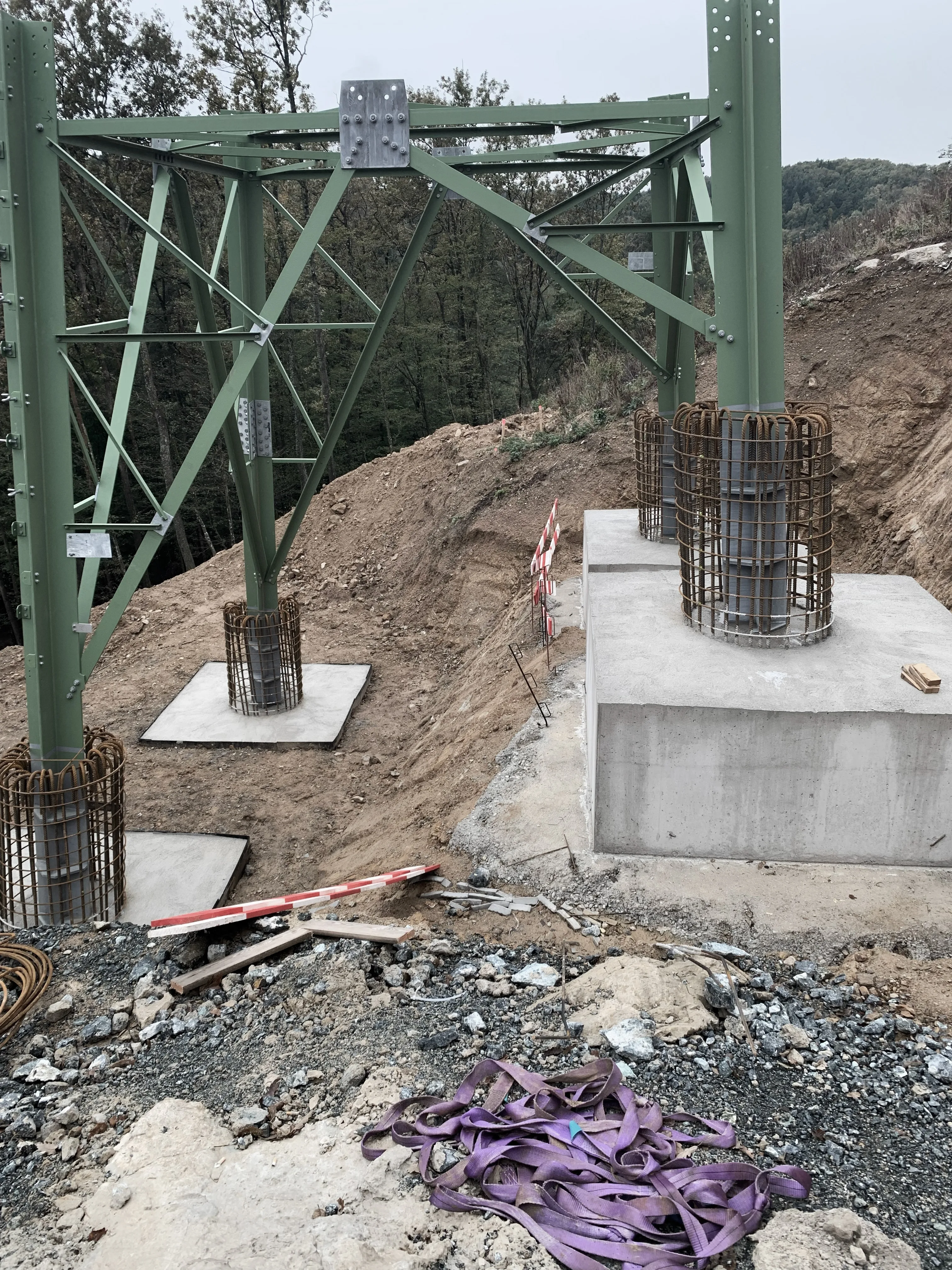 Freileitungsmast aus Stahl auf seinen Betonfundamenten